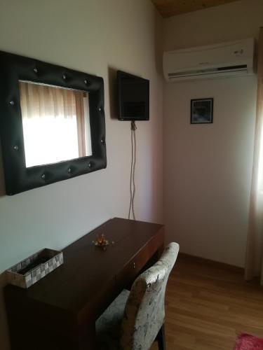 a living room with a table and a television on the wall at Casa do Azibo in Santa Combinha