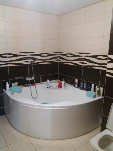 a bath tub in a bathroom with a toilet at Sloneczny pokoj in Świnoujście