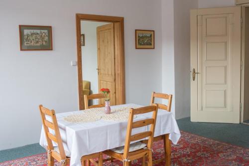 a table with two chairs and a vase on it at Penzion Signum Laudis in Velké Hamry