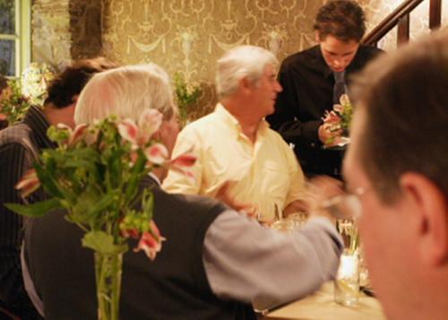 a group of people sitting at a table in a restaurant at Bear Crickhowell in Crickhowell