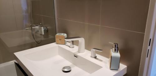 W łazience znajduje się biała umywalka i lustro. w obiekcie Aventura 108 w BuenosAires