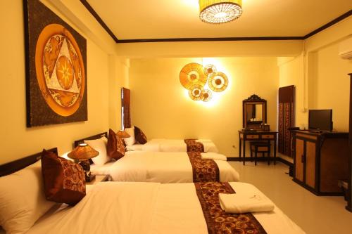 ein Hotelzimmer mit 4 Betten und einem TV in der Unterkunft Kongkam House in Mae Sai