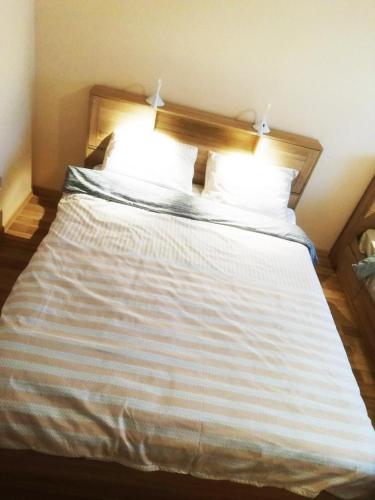a large bed with white sheets and pillows at Couple getaway to a freshly renovated apartment in Pärnu