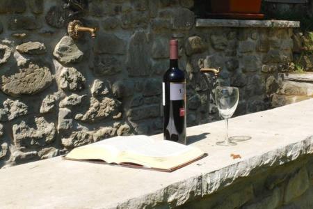 a bottle of wine and a glass on a table at Il Molino Di Serravalle in Bibbiena