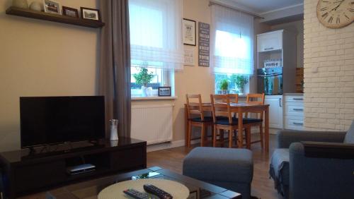 ギジツコにあるApartament Rodzinnyのリビングルーム(テレビ、テーブル、椅子付)