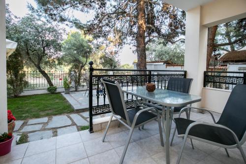 a patio with a table and chairs and a fence at Villa Katerina in Potos