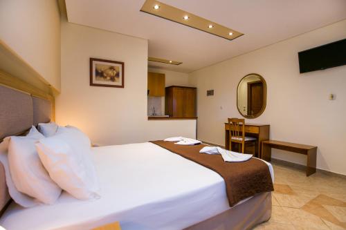 a bedroom with a bed and a table and a mirror at Villa Katerina in Potos