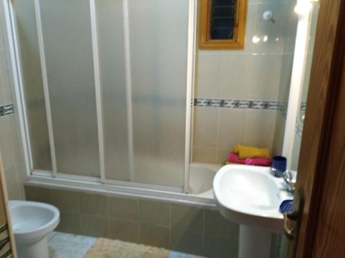 a bathroom with a shower and a sink and a toilet at Apartamentos La Banda in Playa de Santiago