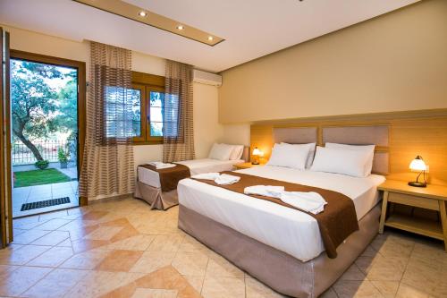 a bedroom with two beds and a large window at Villa Katerina in Potos