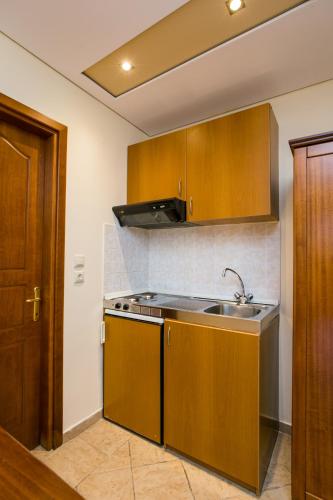 a kitchen with wooden cabinets and a sink at Villa Katerina in Potos