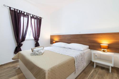 1 dormitorio con 1 cama grande y cabecero de madera en Apartment Francesco, en Šibenik