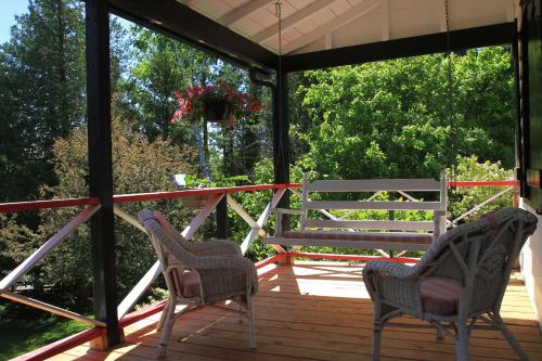 2 chaises et un banc sur une terrasse dans l'établissement Auberge La Châtelaine, à La Malbaie
