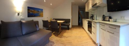a kitchen and living room with a couch and a table at Hotel Garni Grünmoos in Sankt Jakob in Defereggen