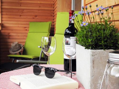 a table with a bottle of wine and glasses at Leos Alpenblume inklusive Sommer Bergbahnticket in Oberstdorf