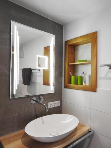 a bathroom with a sink and a mirror at Leos Alpenblume inklusive Sommer Bergbahnticket in Oberstdorf