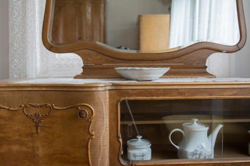 a wooden dresser with a mirror and a bowl on it at Penzion Signum Laudis in Velké Hamry