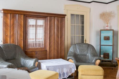a living room with two chairs and a table at Penzion Signum Laudis in Velké Hamry