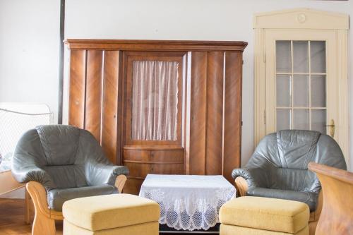 two chairs and a table in a living room at Penzion Signum Laudis in Velké Hamry