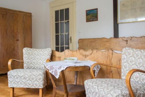 a table and two chairs in a room at Penzion Signum Laudis in Velké Hamry