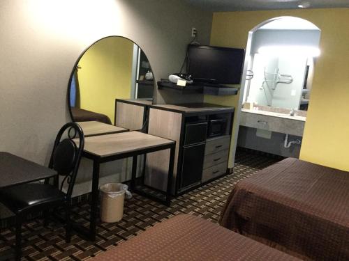 a small room with a desk and a mirror at Luxury Inn and Suites Seaworld in San Antonio