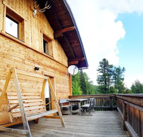 a wooden deck with a table and chairs on a building at Almhütte Kristabauer in Predlitz