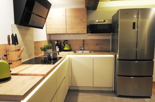 a kitchen with white cabinets and a stainless steel refrigerator at Leos Alpenblume inklusive Sommer Bergbahnticket in Oberstdorf