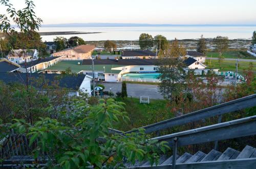 a view of a house with a pool and the ocean at Hotel-Motel Les Voitures d'Eau in L'Isle-aux-Coudres