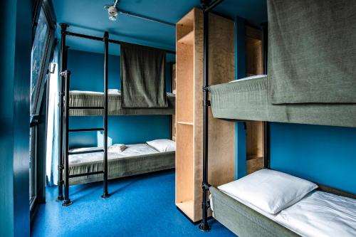 ヴァーネミュンデにあるDOCK INN Hostel Warnemündeの青い壁の客室で、二段ベッド2台が備わります。