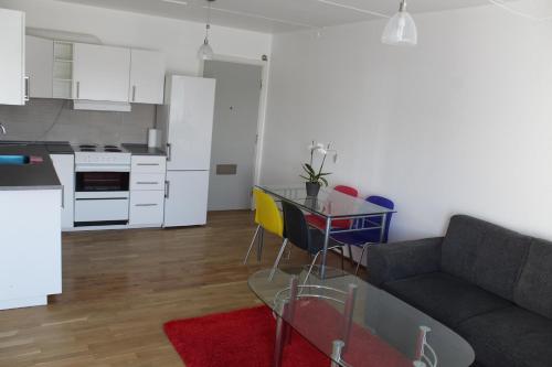 a living room with a couch and a table and a kitchen at Eremitageparken in Kongens Lyngby
