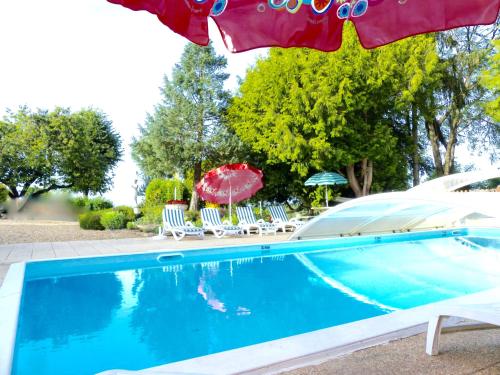 a swimming pool with chairs and umbrellas at Domaine du Parc in Montsoreau