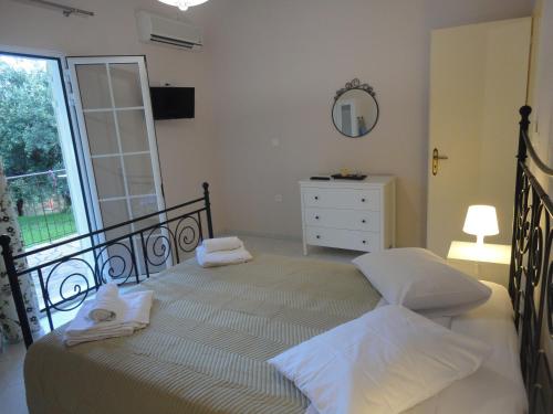 a bedroom with a bed and a dresser and a window at Yialos apartments in Kefallonia