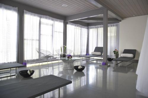 a living room with tables and chairs and windows at Carlisle Bay in Old Road