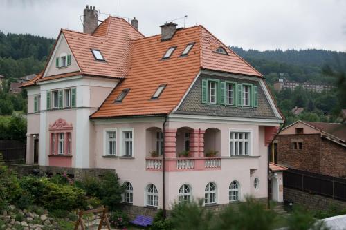 a large white house with an orange roof at Penzion Signum Laudis in Velké Hamry