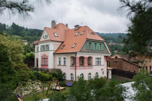a large white house with a red roof at Penzion Signum Laudis in Velké Hamry