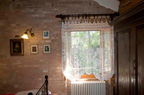 a window with a white curtain and a radiator at B&B La Cappellania in Montegiorgio