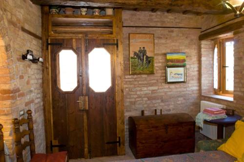 a room with a wooden door and a brick wall at B&B La Cappellania in Montegiorgio