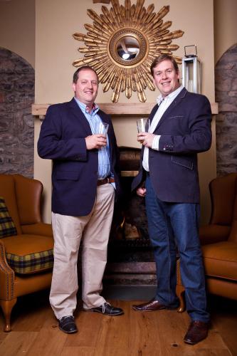 two men in suits are holding wine glasses at The Ancient Gatehouse & Rugantino Restaurant in Wells