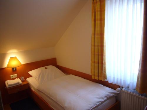 a small bed in a room with a window at Hotel Deutsches Haus in Kaub
