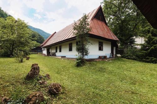 a white house with a red roof in a yard at Paul's country house | region Donovaly in Horná Turecká