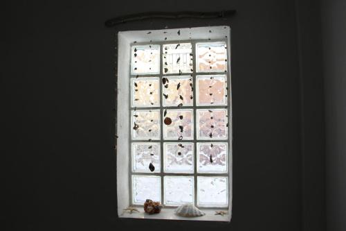 Una ventana con un montón de pájaros. en Matina's Apartments en Prinos