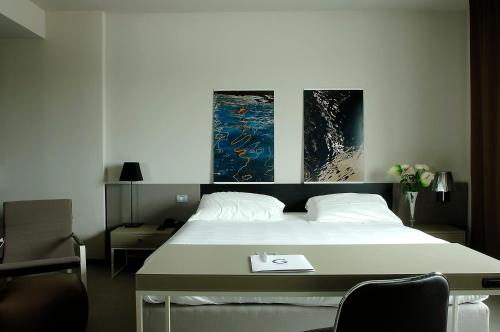 una camera da letto con un letto e due dipinti alle pareti di G Hotel Ancona a Osimo