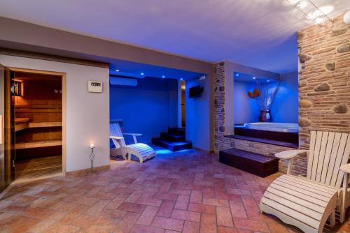 Camera blu con vasca, divano e sedia di Hotel Sole Mio a Rimini