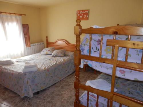 ein Schlafzimmer mit zwei Betten und einem Etagenbett in der Unterkunft Hostal El Portalico in Linares de Mora
