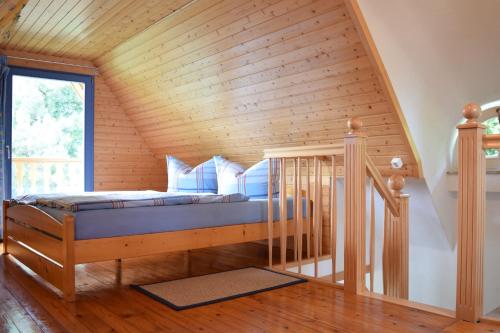 Cama en habitación con techo de madera en Reethaus im Ostseebad Trassenheide en Trassenheide