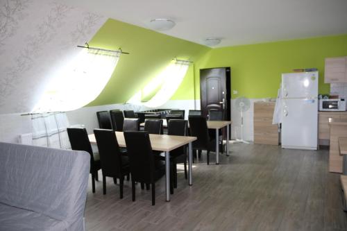 a dining room with tables and chairs and a refrigerator at Hortobágyi Kemencés Vendégház in Hortobágy