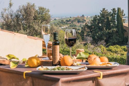 a table with glasses of wine and food on it at Villa La Lumia B&B Suites & Apartments in Agrigento