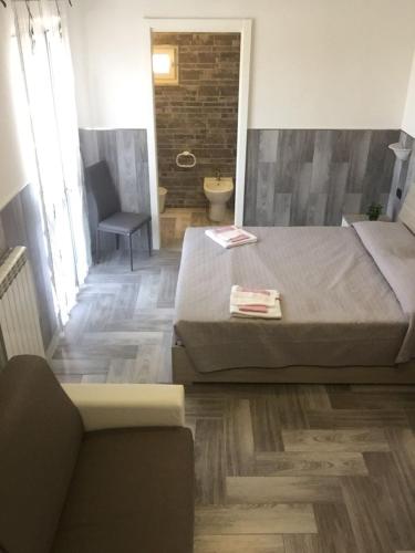 a bedroom with a bed and a chair and a bathroom at Beb la lupa in Rome