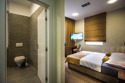 a bedroom with a bed and a bathroom with a television at Central Luxury Rooms in Omiš