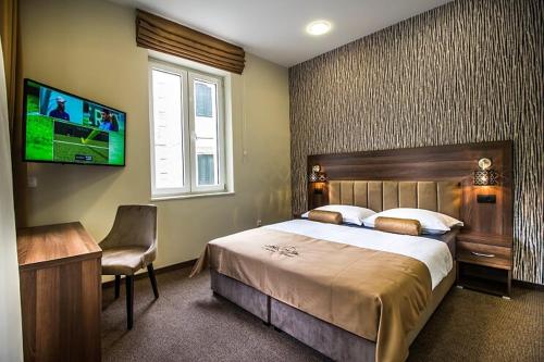 a bedroom with a large bed and a tv on the wall at Central Luxury Rooms in Omiš