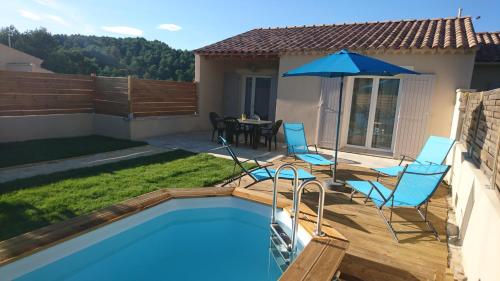 einen Pool mit 2 Stühlen und einem Sonnenschirm in der Unterkunft LES LAUZES DE ST MICHEL-LA SARRIETTE in Entrechaux